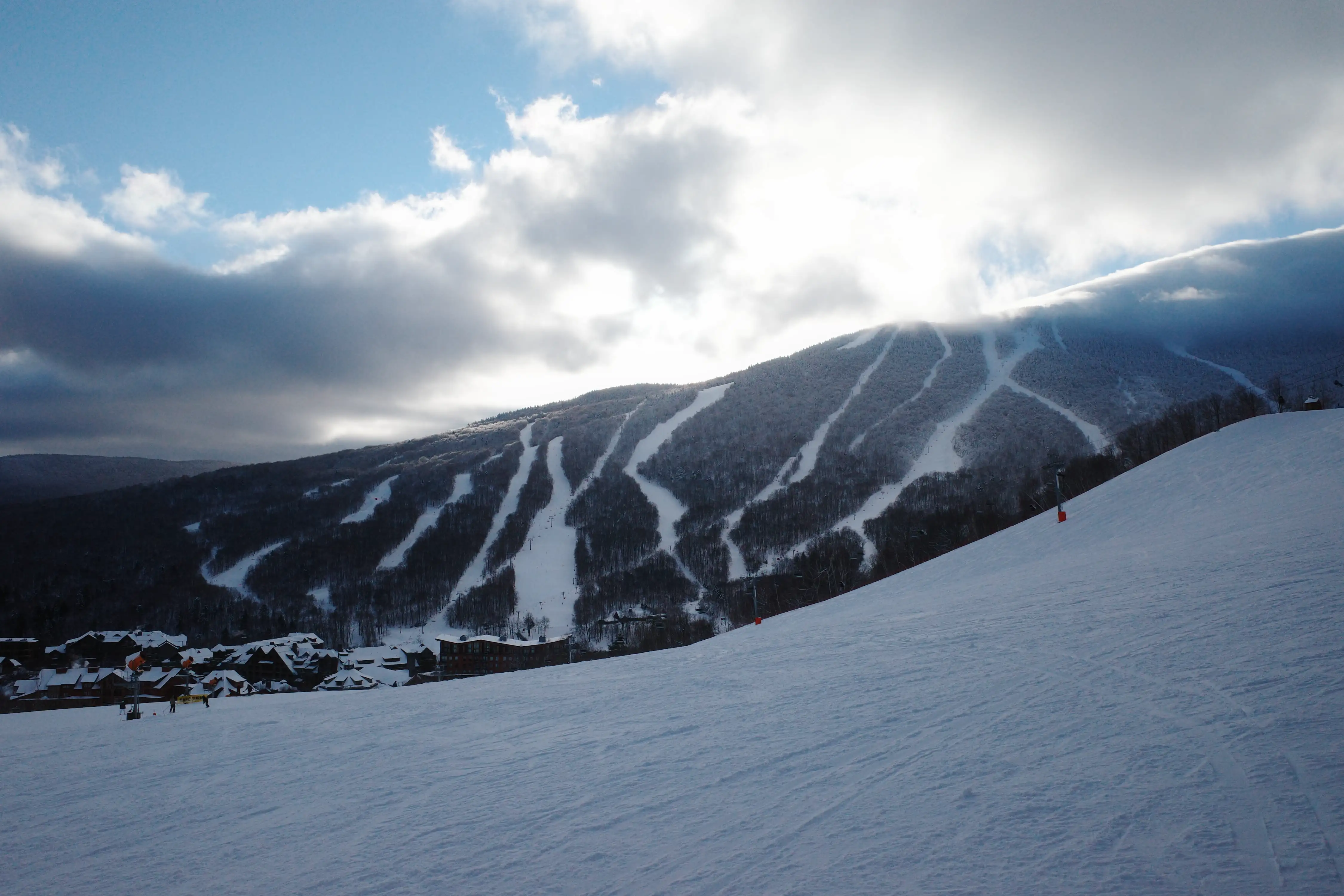 Ski trails cut down a cloud-wrapped mountain